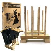 A wooden boot holder stand with six vertical pegs, shown holding several black rubber boots. The natural wood stand is displayed alongside its brown cardboard packaging box on a white background.