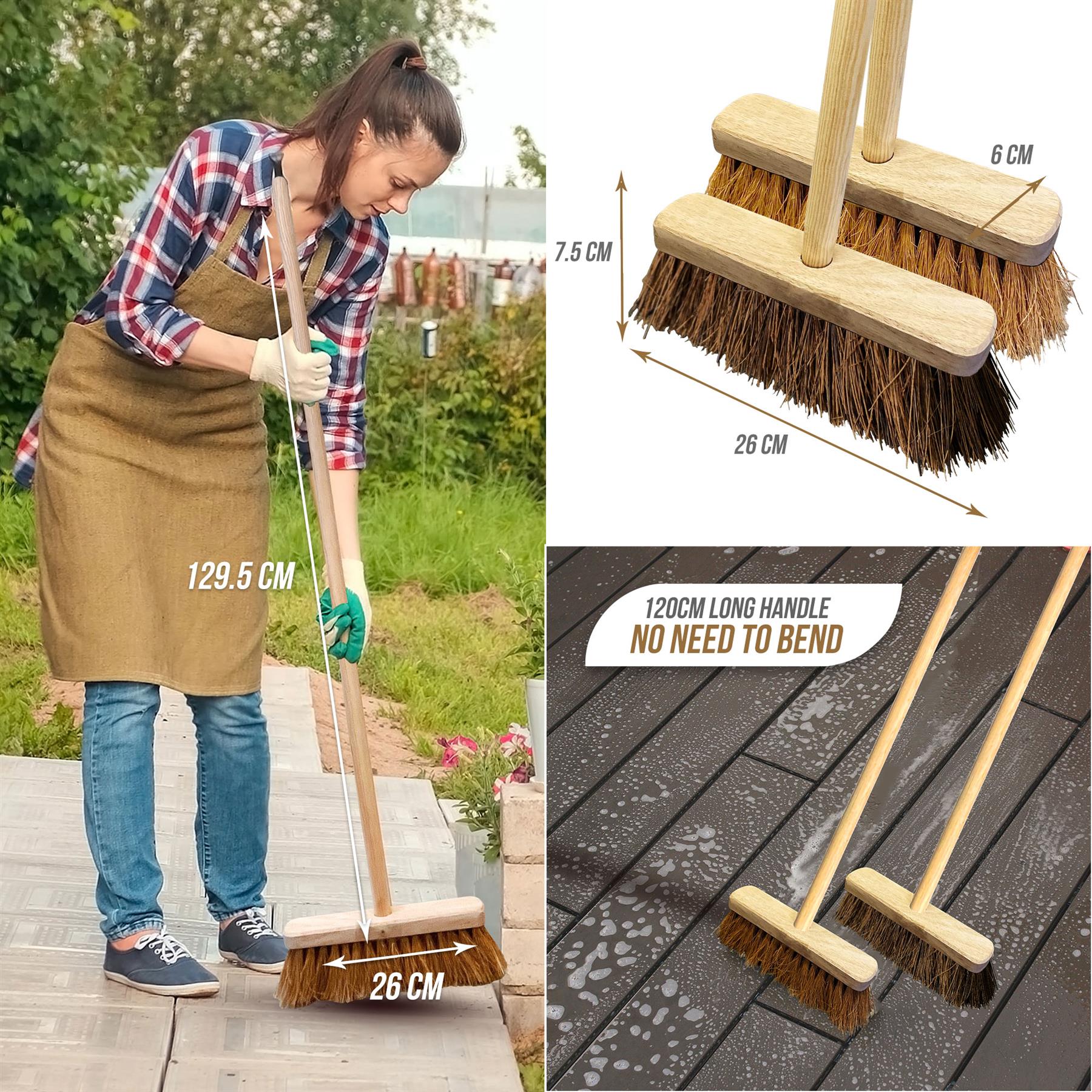Woman using a broom outdoors with measurements and another broom on a wooden surface.