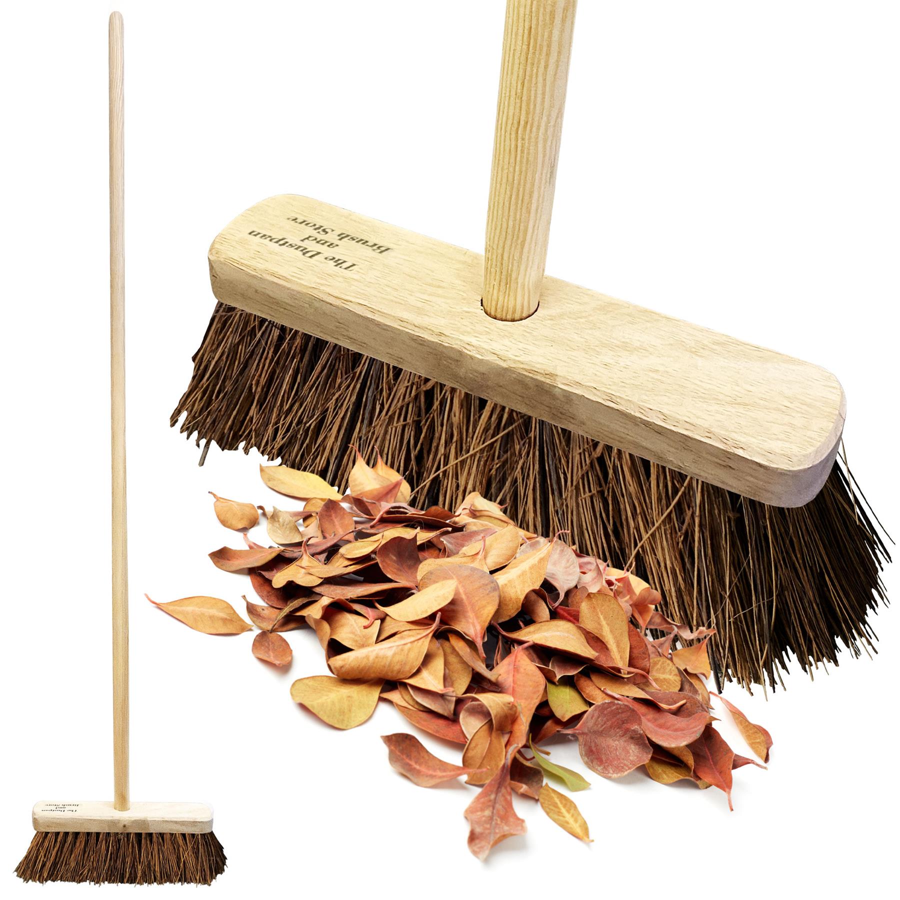 10" Stiff Bassine Broom on a white background with leaves been swept up