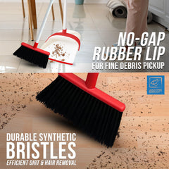 Cleaning brush with red handle and black bristles on a wooden floor.