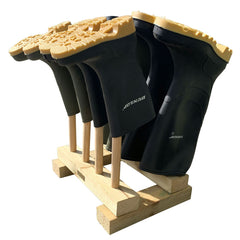 4 pairs of wellingtons stored on wooden welly boot stand - on a white background 