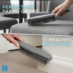 A grey cleaning brush with flexible bristles is shown being used on a grey fabric chair and along a white baseboard. Text overlays read 'PERFECT FOR FABRIC CHAIRS' and 'REACHES TIGHT EDGES'. 