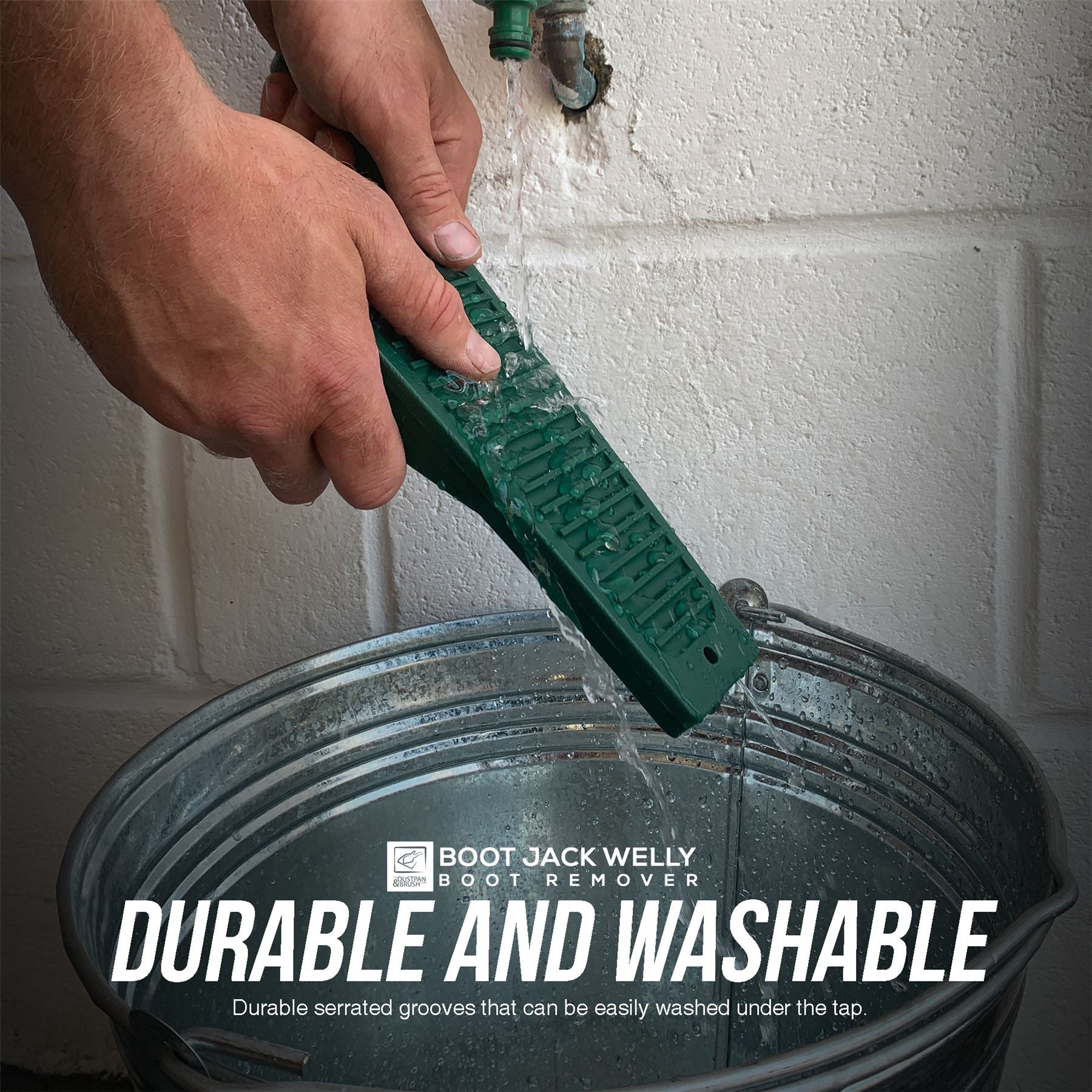 Person cleaning Boot Jack in a bucket with a white wall background