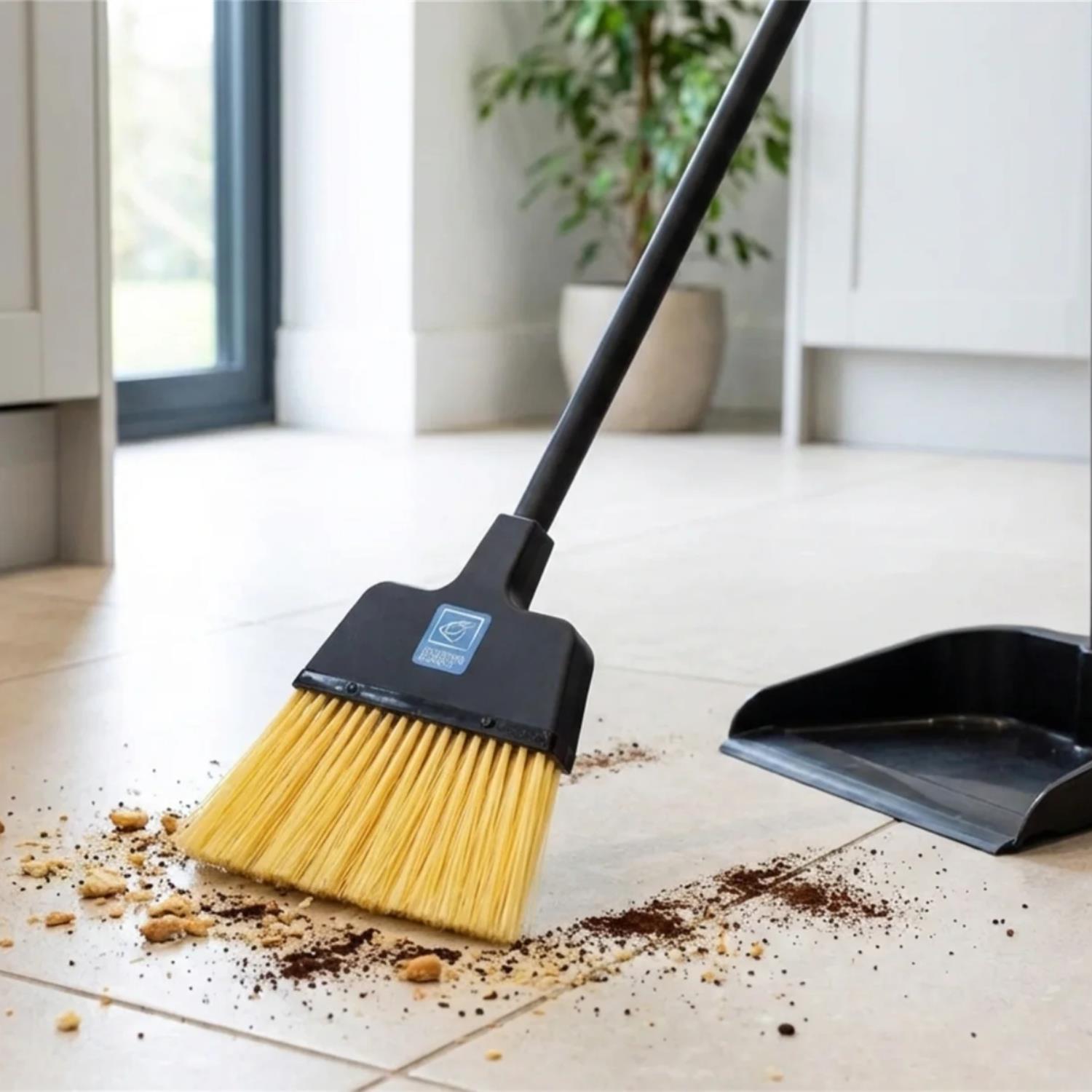 Replacement Stiff Brush for Long Handled Dustpan and Brush Set shown in a bright indoor room, with crumbs on the floor being swept up.