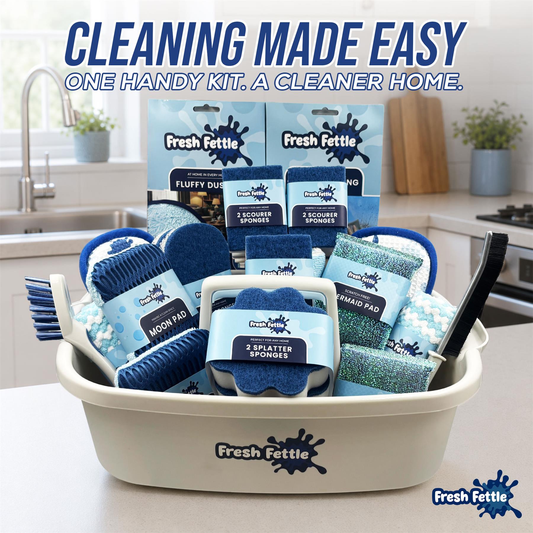 A Fresh Fettle cleaning kit displayed in a white plastic basket on a kitchen counter, with a sink and kitchen background visible. The kit includes blue and white cleaning sponges, scrubbers, mops, and a black brush, with multiple branded packages arranged inside the basket.
